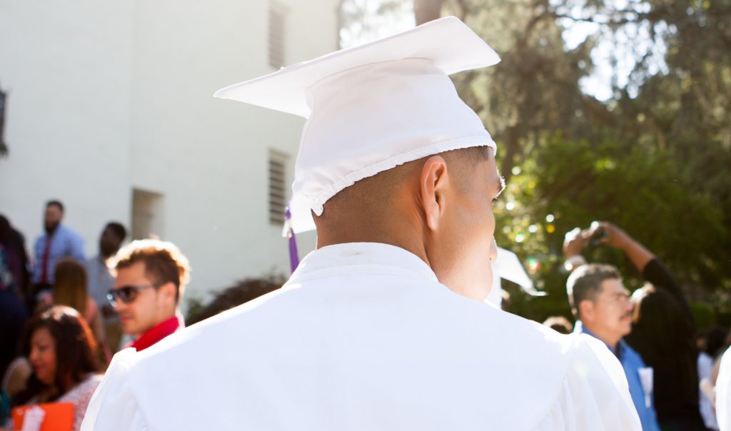 Aspire graduate photographed from behind, looking slightly to the right so you can see a profile of his face.