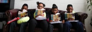 Aspire Memphis Students reading Bud Not Buddy on a couch