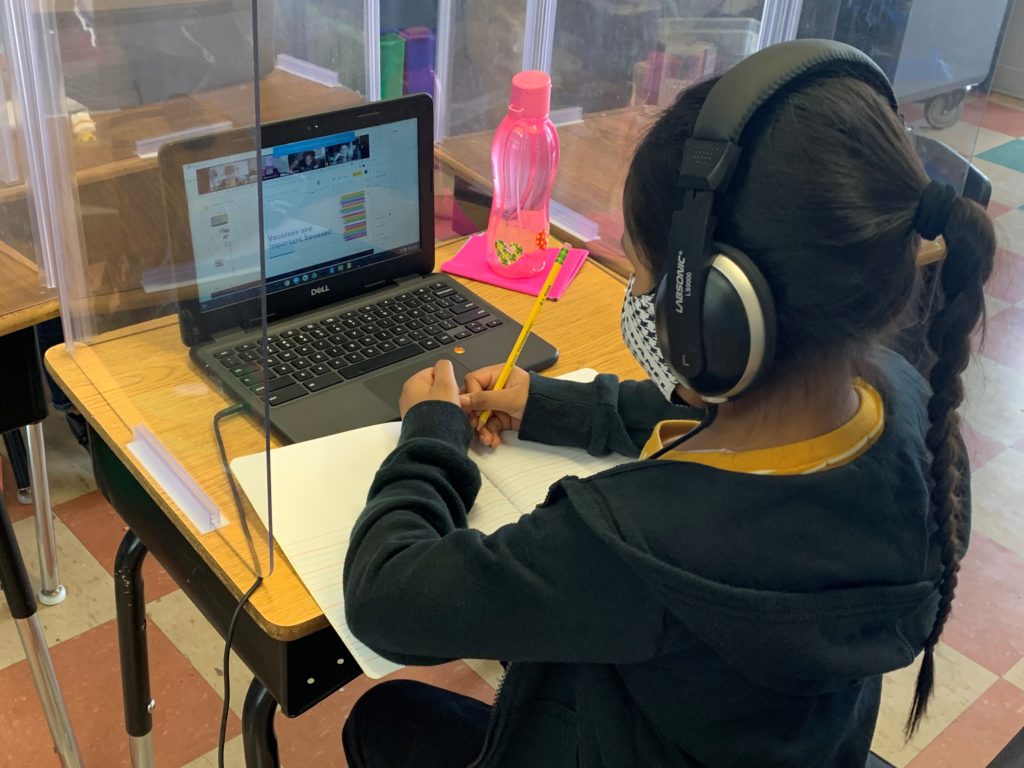 Aspire BA scholar completing lesson on device in class.